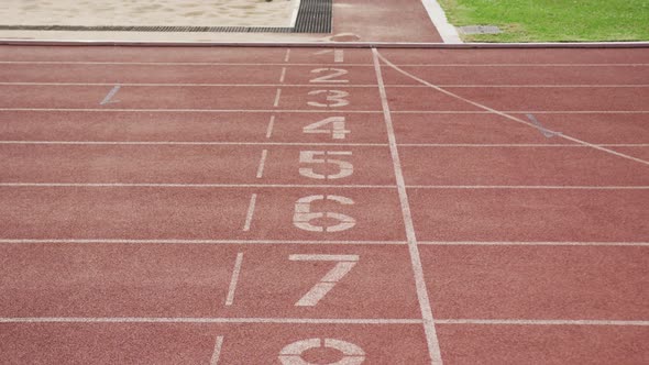 Disabled mixed race man with prosthetic legs running through a finishing line on race track