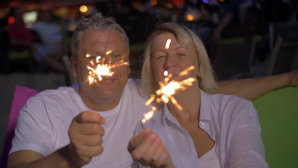 Senior Couple With Bengal Lights Outdoor At Night