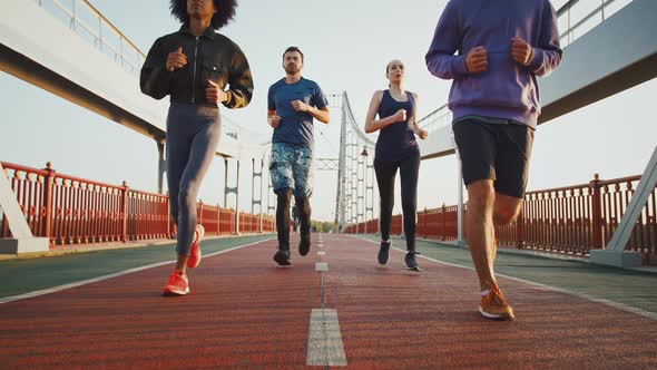 Slow Motion Shot of Runners Group Working Out on Sports Path Close Up