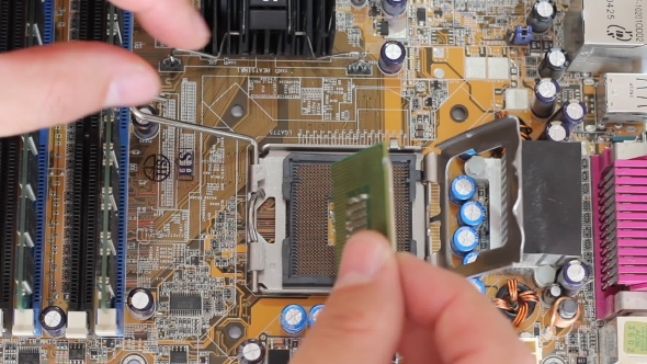 Man Pulls Out a Computer Processor From The Motherboard