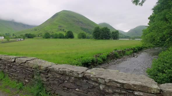 Gravel road and a wall over a stream in the Lake District, UK