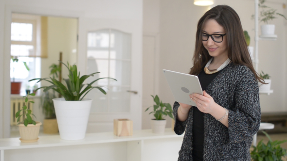 Female Designer Using Tablet, while Standing  in Office
