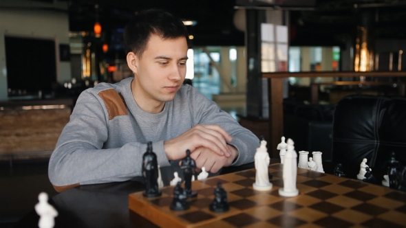 Young Man Playing Chess In The Restaurant