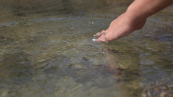 Woman Taking Clear Water At a Lake By Hand