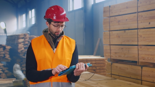 Warehouse Worker Uses a Tablet