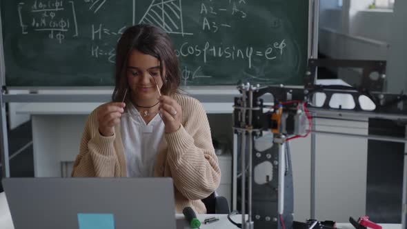 Girl Sits on a Chair and Looks on the Camera in Science Class