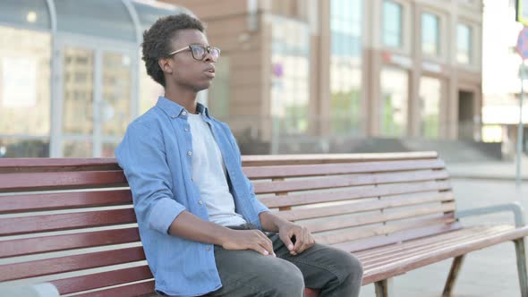 Young African Man Standing and Leaving After Sitting on Bench Outdoor