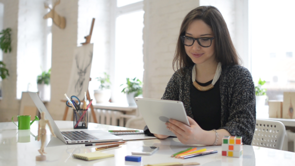 Female Designer Surfing Online on Tablet PC alt