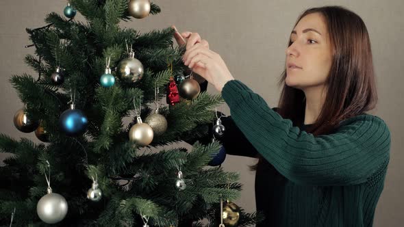 Woman with Loose Hair Decorates Artificial Christmas Tree