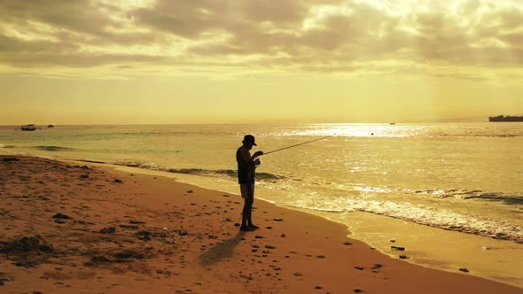 Man alone angler on paradise resort beach voyage by blue ocean and clean sandy background of Lombok 