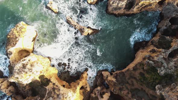 Top view of Atlantic Ocean waves crashing on cliffs. Lagos coastline. Portugal