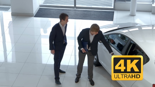 Salesman Demonstrating The Car To Buyer