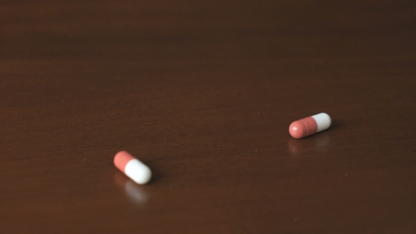 Tablets In The Form Of Capsule Fall On a Table