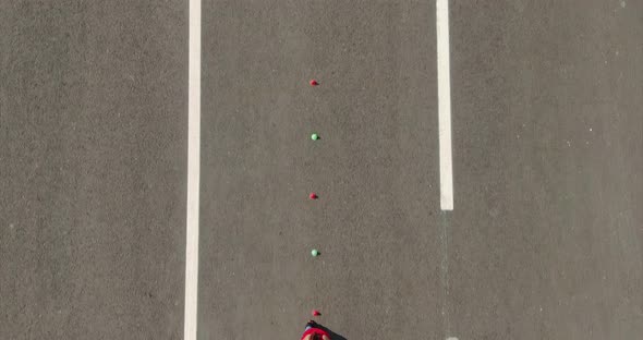 Teenager Girl Goes Around the Cones on Roller Skates Aerial View