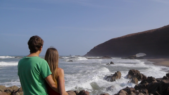 Back View Of a Couple Hugging And Watching The Sea On The Beach Legzira