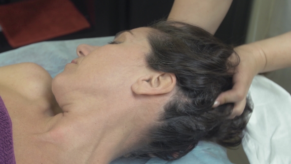 Masseuse Make Healing Massage Of Head To Young Woman