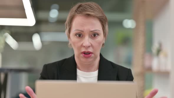 Close Up of Old Businesswoman Reacting To Loss on Laptop 