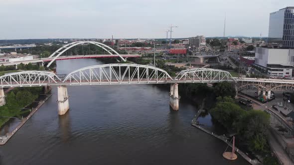 White truss bridges above narrow river by downtown Nashville city, Illinois, aerial approach