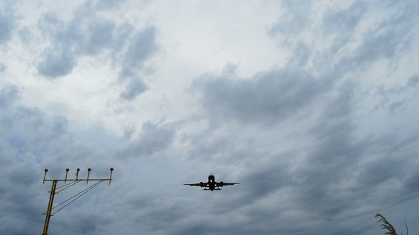 Airplane Arriving to Airport at a Cloudy Day