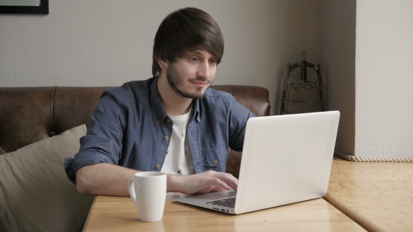 Happy Young Man Freelancer With Modern Laptop In Cafe Taking Cup Of Coffee
