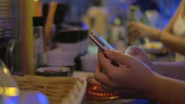 Woman Texting On Mobile In The Bar