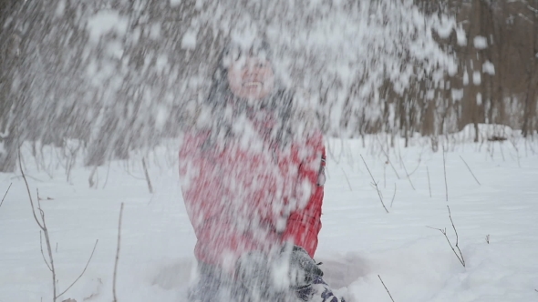 Woman Wearing a Red Jacket Throwing Snow In The Air In Winter Holidays