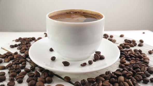 White Cup With Black, Hot Coffee Standing On Brown, Roasted Beans On Sacking