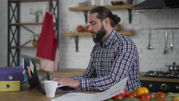 Side View of Handsome Confident Middle Eastern Man Typing on Laptop Keyboard Making Victory Gesture