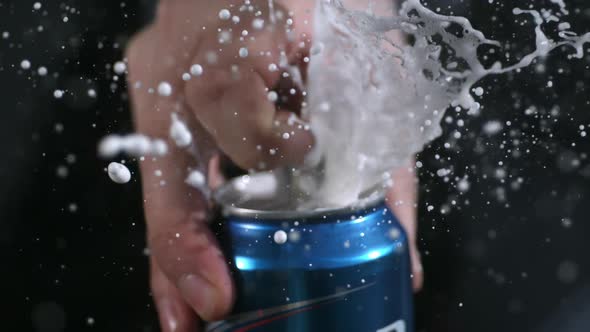 Rotating slow motion of aluminum can opening and spraying.