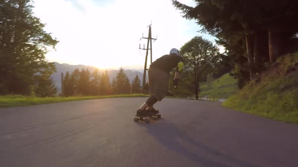 A skateboarder downhill skateboarding racing on a mountain road.