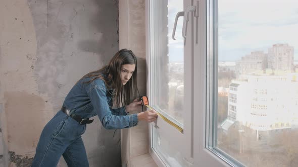 a Beautiful Young Woman Makes Repairs at Home