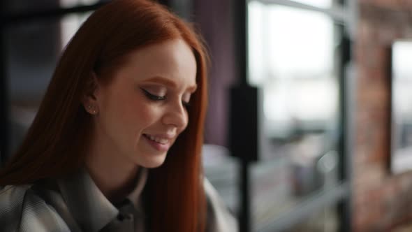 Closeup of Cheerful Redhaired Young Woman Smiling Looking at Laptop Screen Positive Emotion on Face