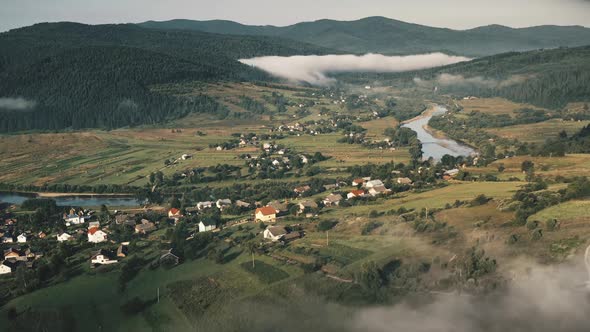 Aerial View Thick Fog on Evergreen Trees Mountains Village Houses