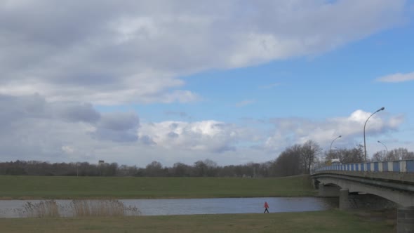 Man is Walking Along River Car Bridge Cars