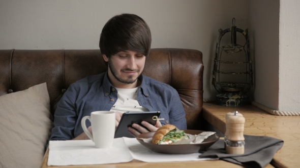 Hipster Man Using Digital Tablet  Eating Healthy Breakfast