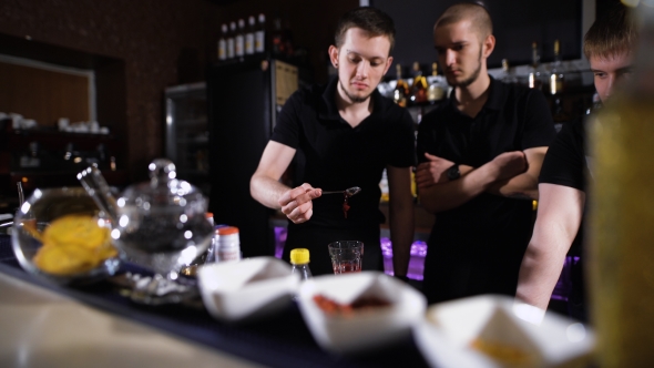 Several Bartenders In Stylish Black Shirts, Work In Intensive Mode
