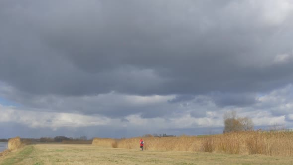 Man is Running Away by Dry Field Thunderclouds