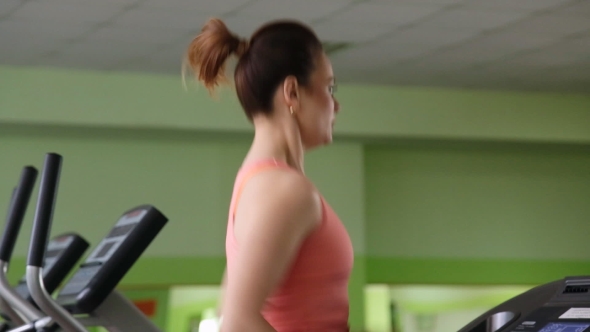 Attractive Young Woman Running On a Treadmill