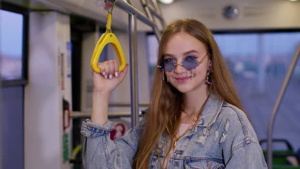 Attractive Young Woman Passenger Riding at Public Modern Bus or Tram Transport Looking Out Window