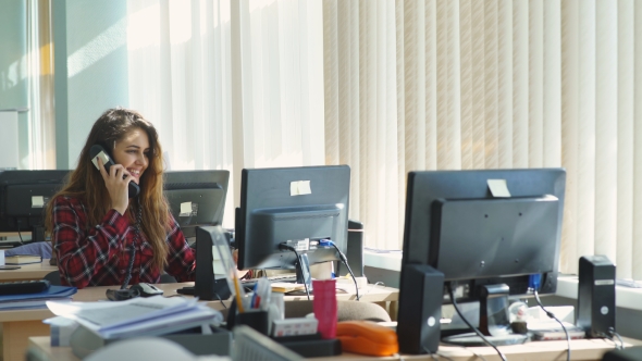 Beautiful Girl Sitting In Office And Talking On The Phone