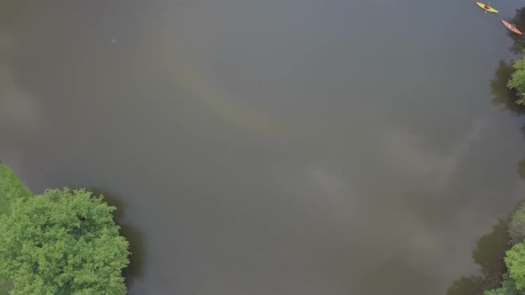 Aerial top down shot of a man and woman kayaking in a pond