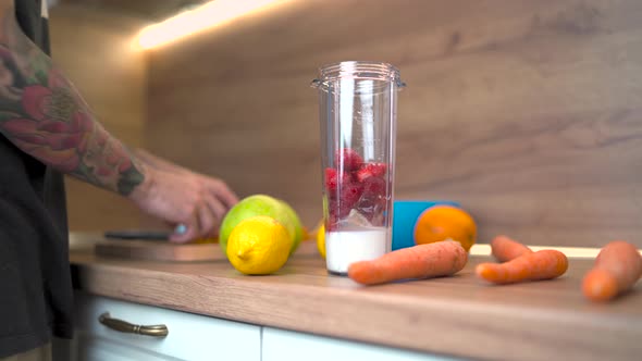 Male Hands Putting Strawberries for a Smoothie