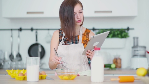 Woman Is Shaking Up Eggs And Look On The Pad