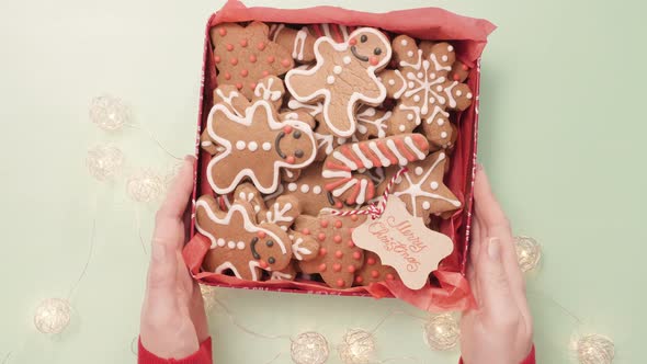 Traditional home made gingerbread cookies as food gifts on blue background with Christmas light.