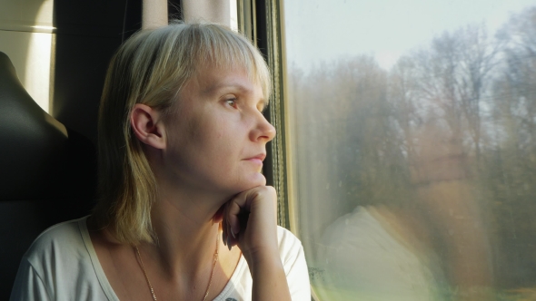 A Woman Looks Out The Window Of The Train