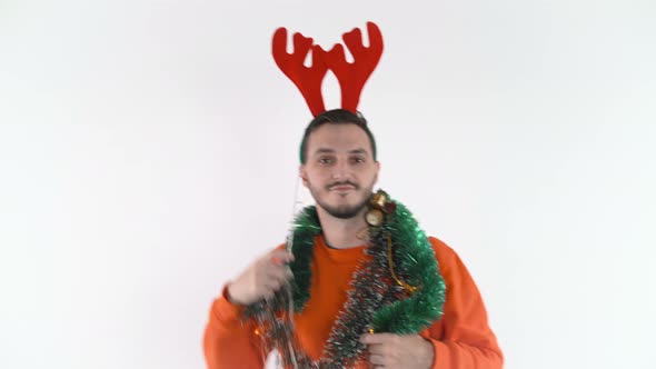 Young Man with Reindeer Antlers and Christmas Lights Dancing and Singing