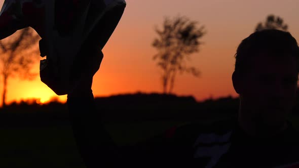 motocross rider raises helmet in celebration sunset 4k