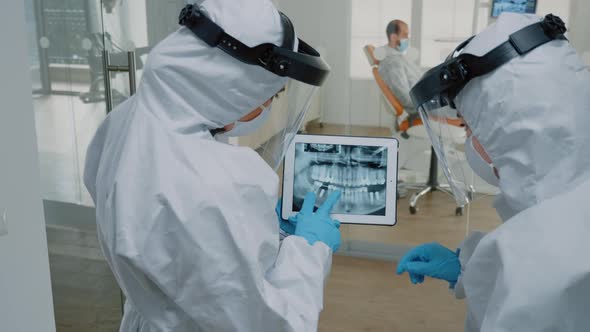 Orthodontists at Dental Clinic Holding Digital Tablet with