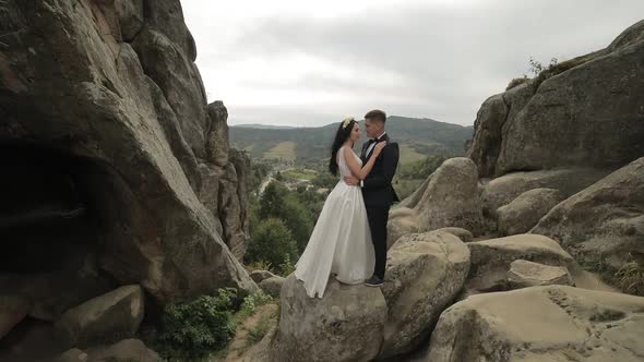 Groom with Bride Standing on the Mountain Hills. Wedding Couple. Newlyweds