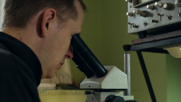 Scientist Looking Into a Microscope alt